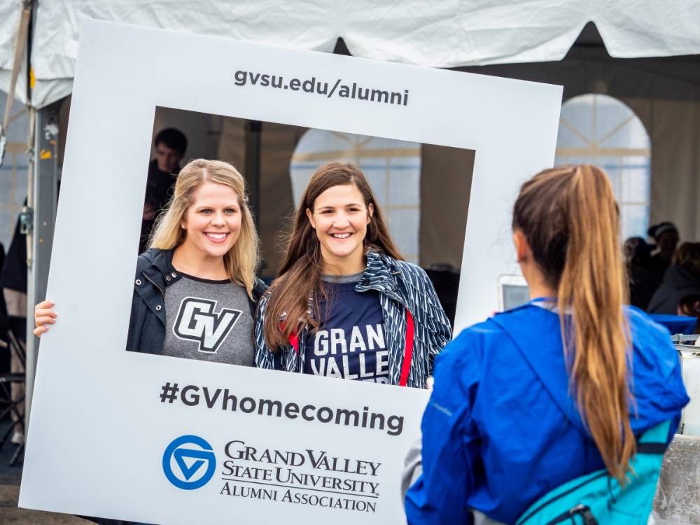 Alumnae pose with the #GVhomecoming sign